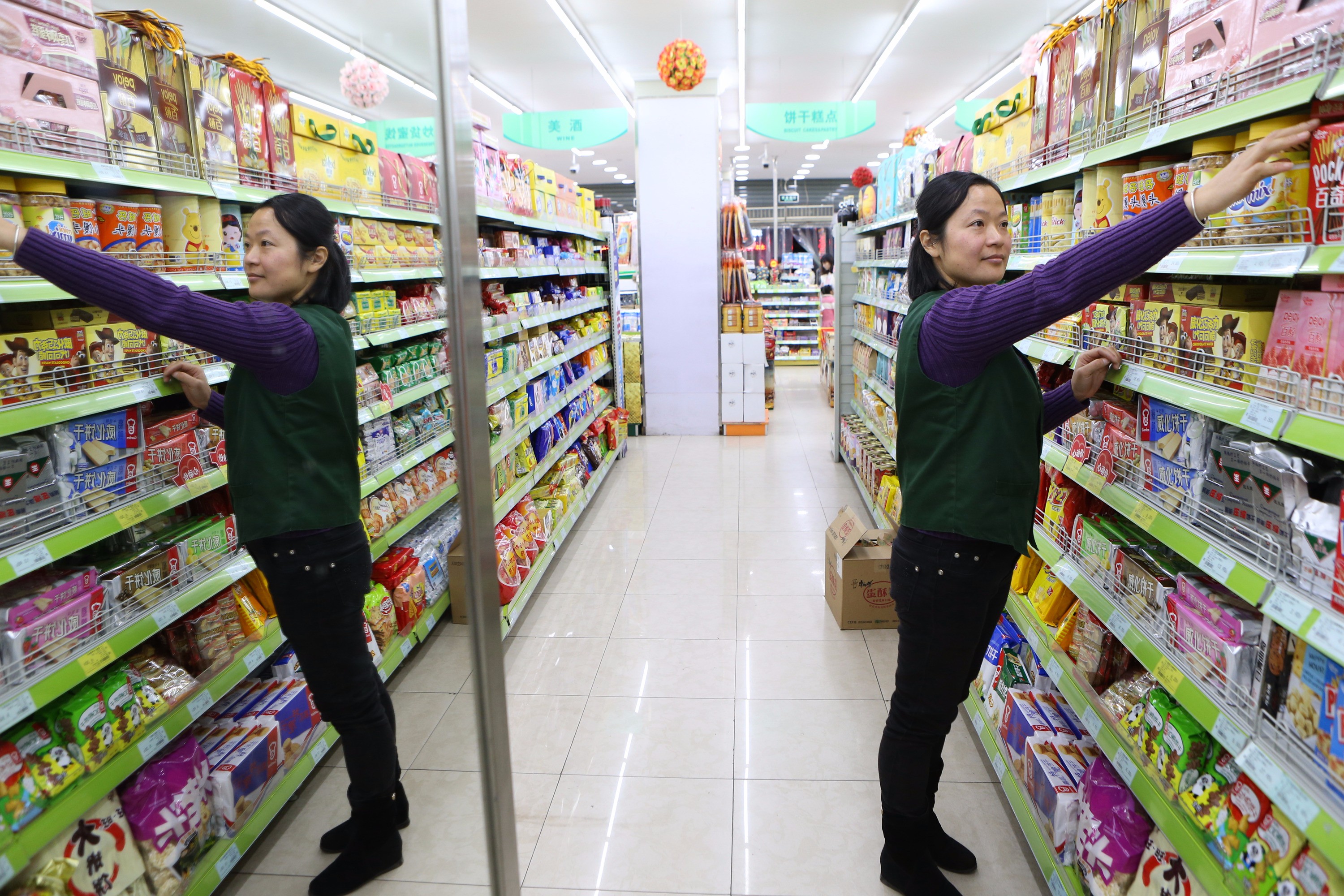 2016年12月30日，上海，张君平在超市忙碌。