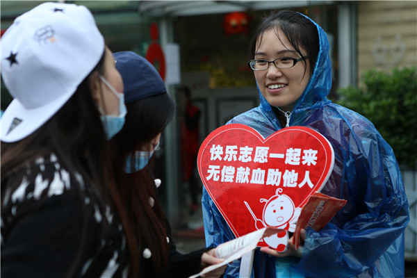 志愿者举牌宣传无偿献血.jpg