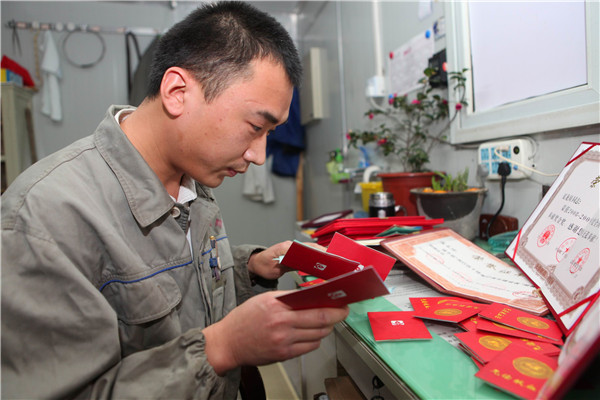 2011年12月21日 夏龙须翻看他的荣誉证书及献血证.jpg